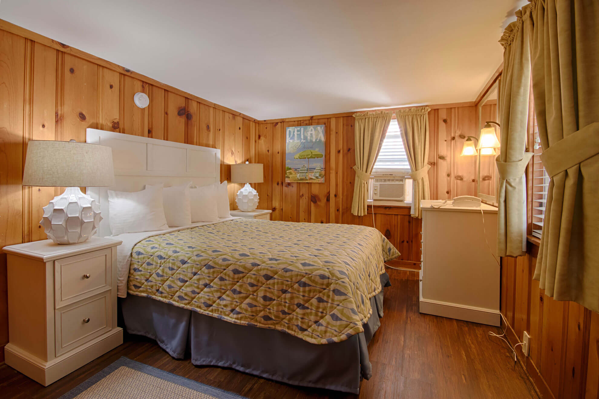 a bed room with a neatly made bed and wooden walls