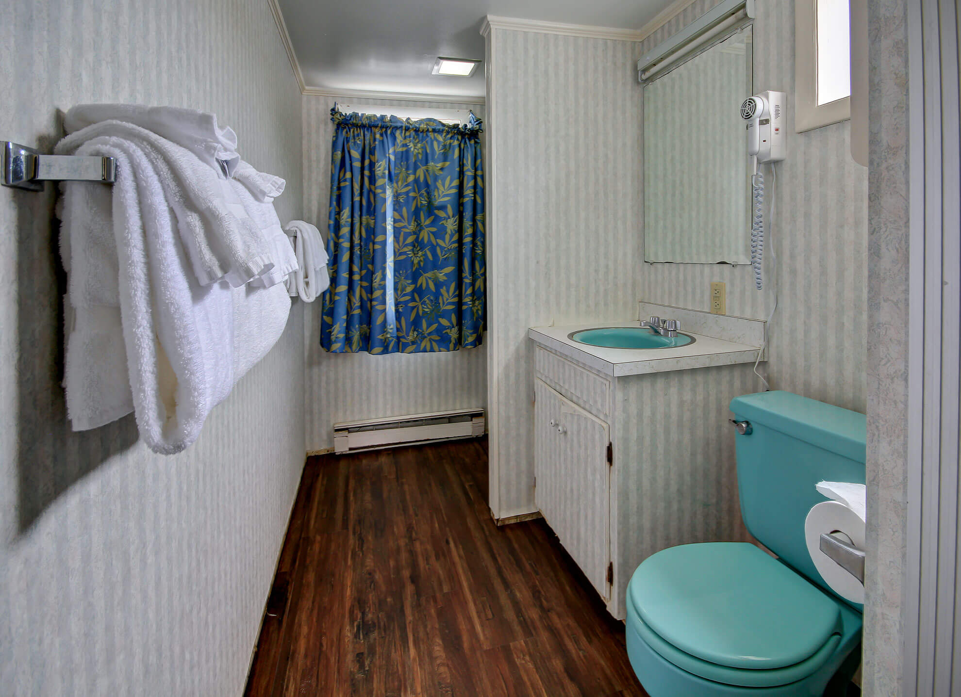 a bathroom with a toilet, sink, and mirror