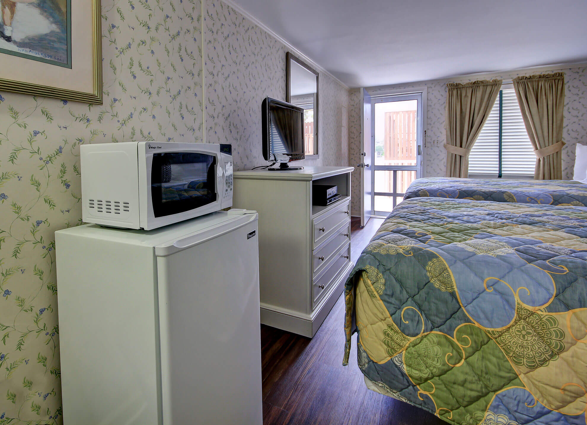 a hotel room with a bed and a refrigerator