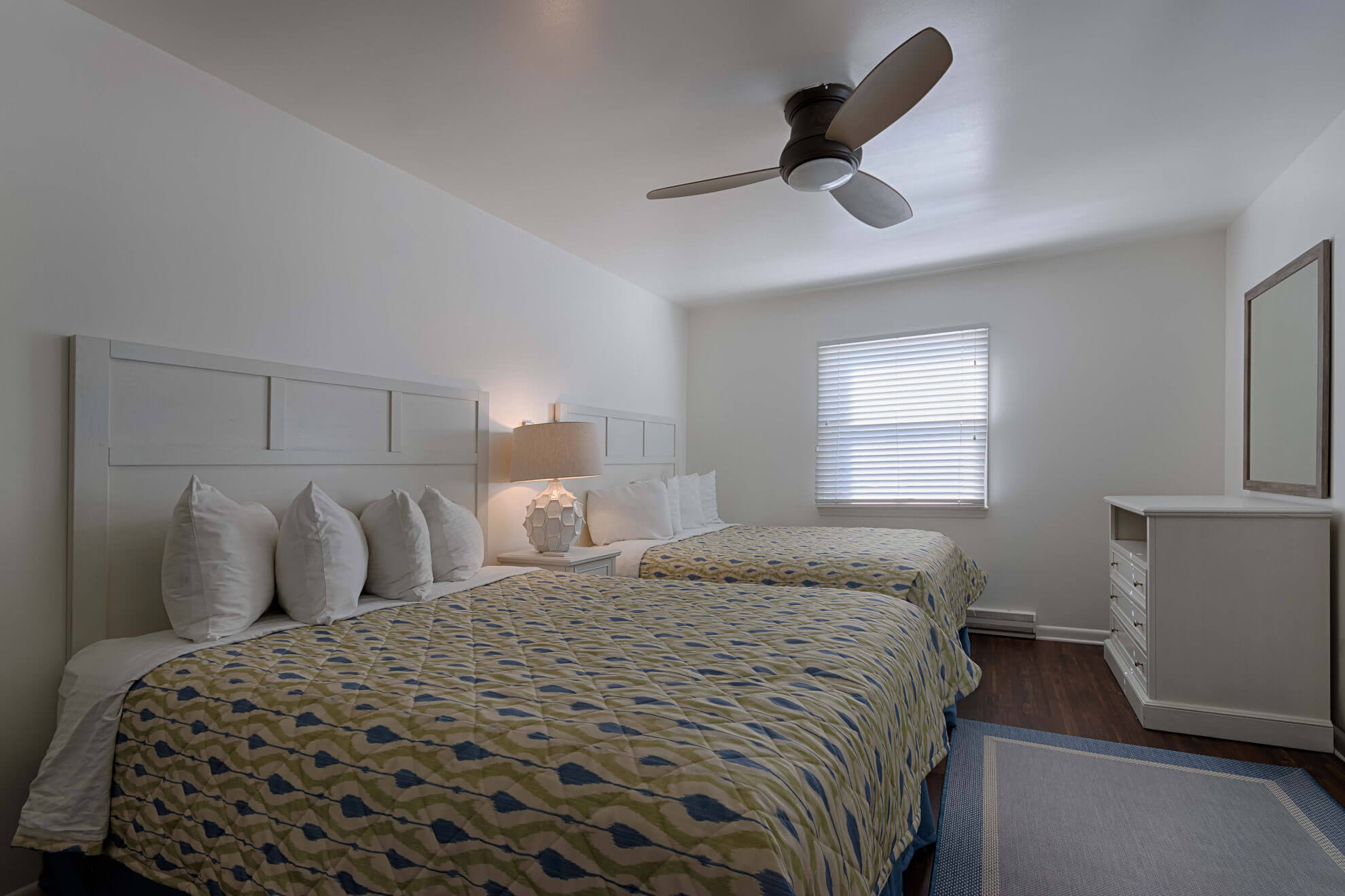 a bedroom with two beds and a ceiling fan