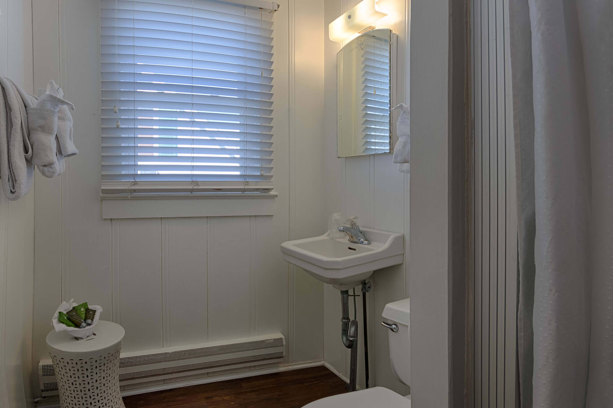 a bathroom with a toilet, sink, and window