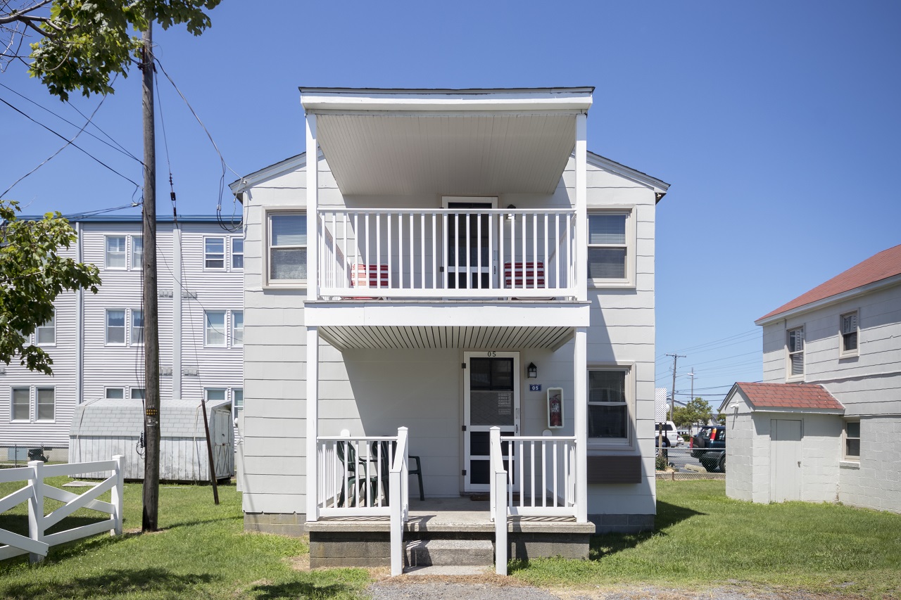 a white two story house with a balcony