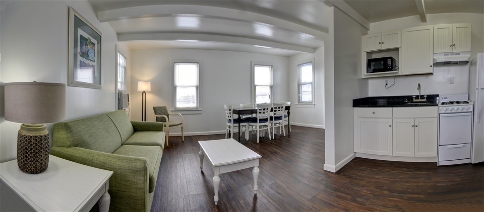 a living room filled with furniture and a kitchen