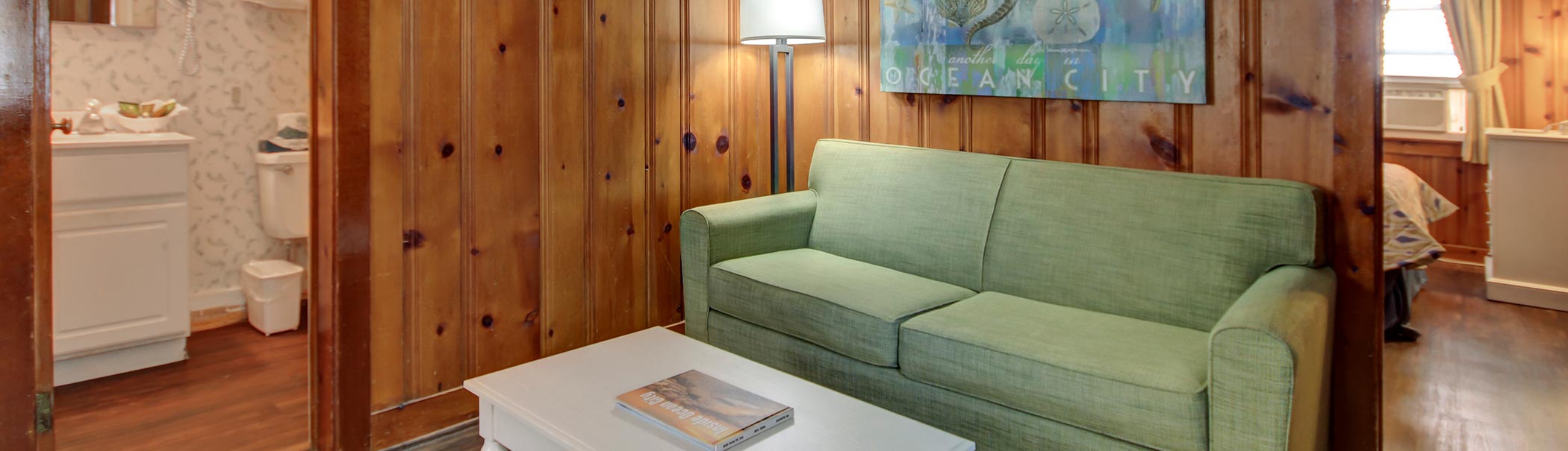 a living room with wood paneling and a green couch