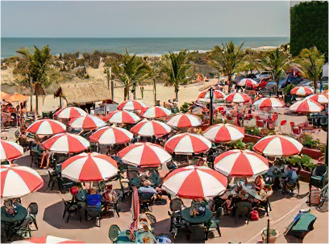 a bunch of red and white umbrellas on a beach