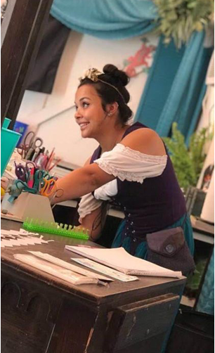 a woman sitting at a desk in front of a mirror