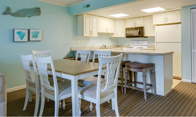 a kitchen and living room with a table and chairs