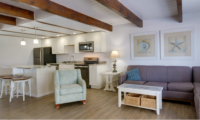 a living room filled with furniture and a kitchen