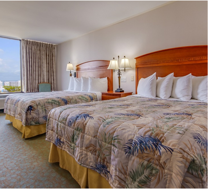 a hotel room with two beds and a large window