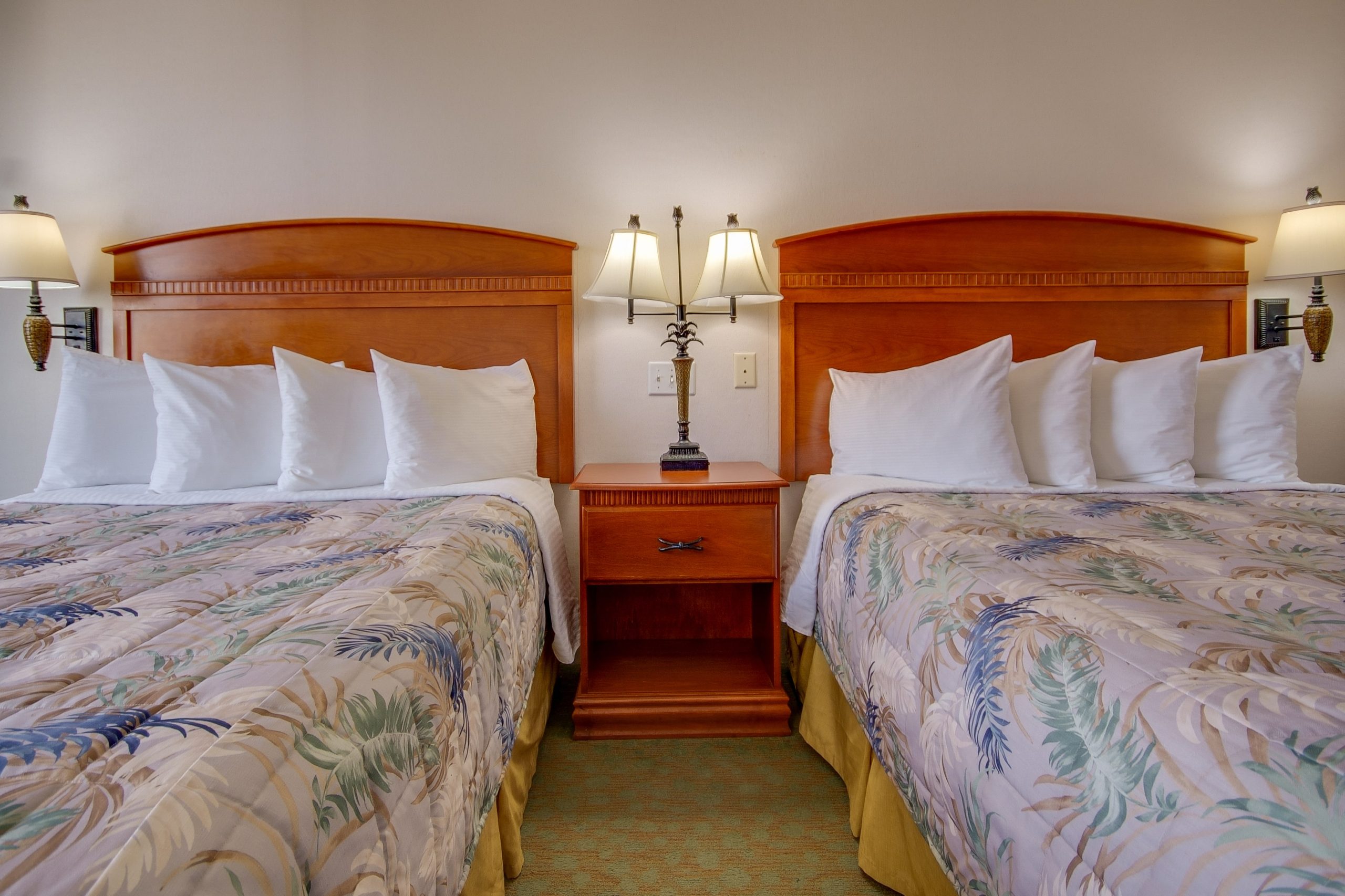 a hotel room with two beds and two lamps