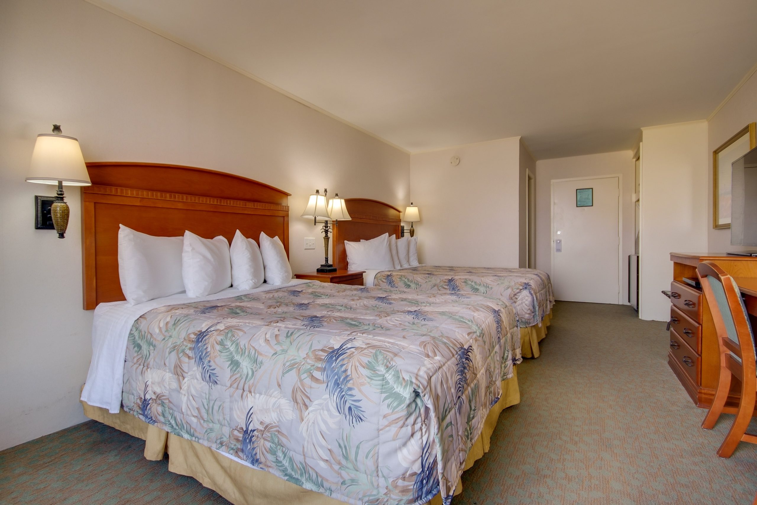 a hotel room with two beds and a desk