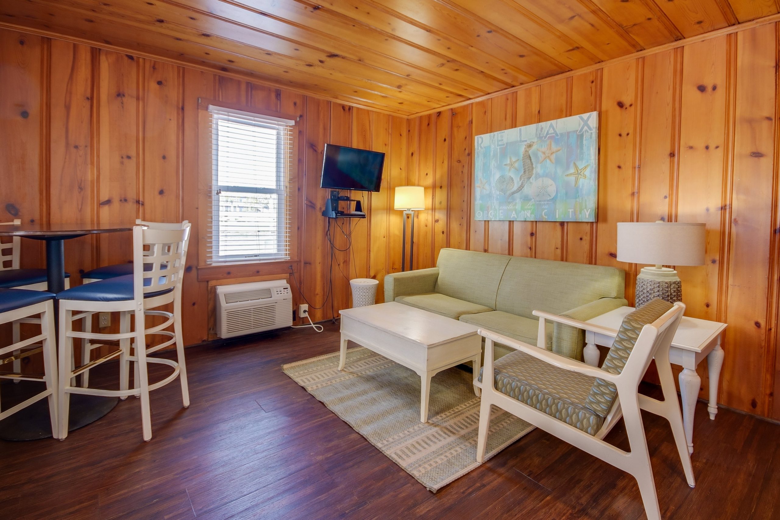 a living room filled with furniture and wooden walls