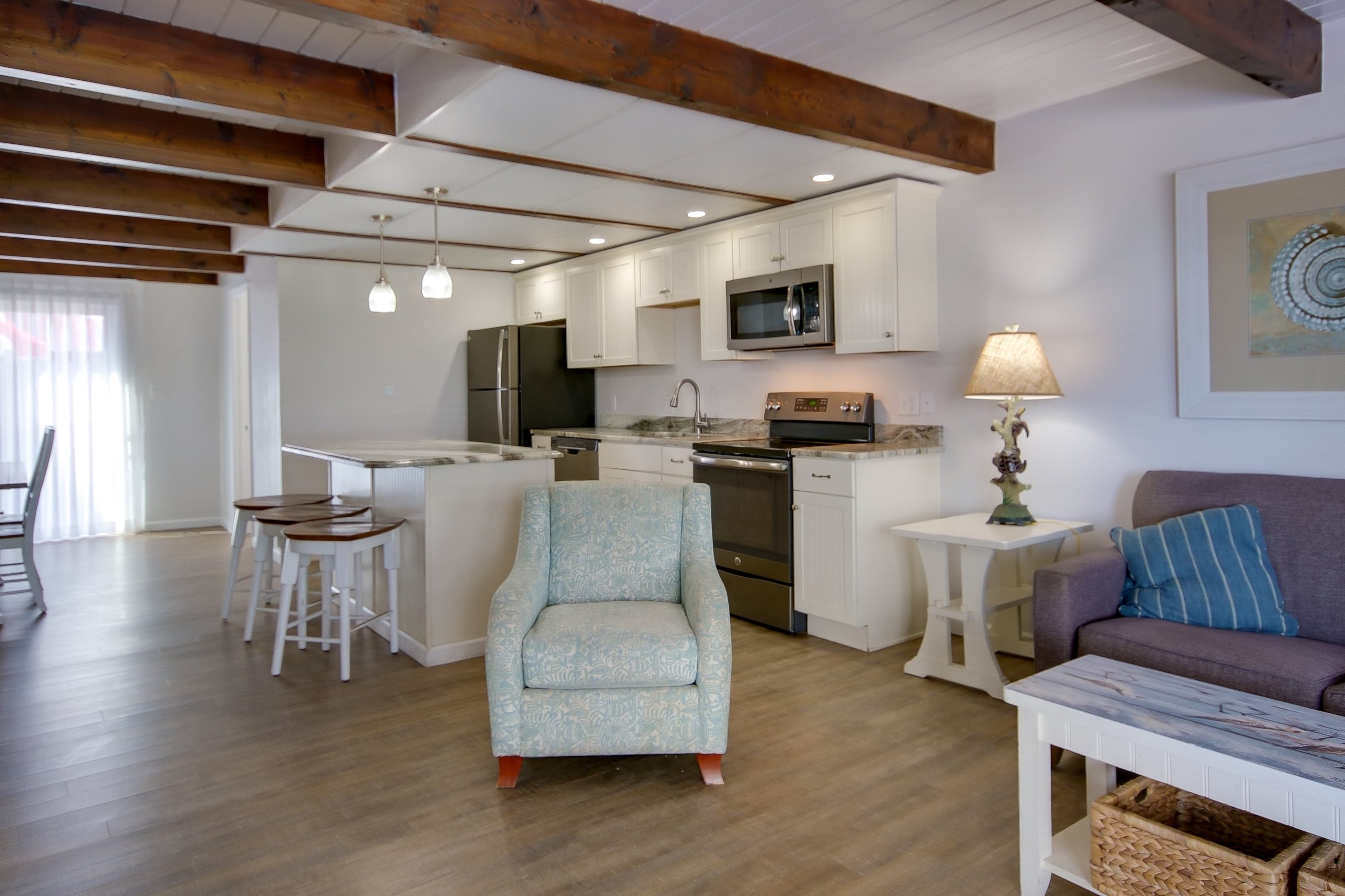 a living room filled with furniture and a kitchen