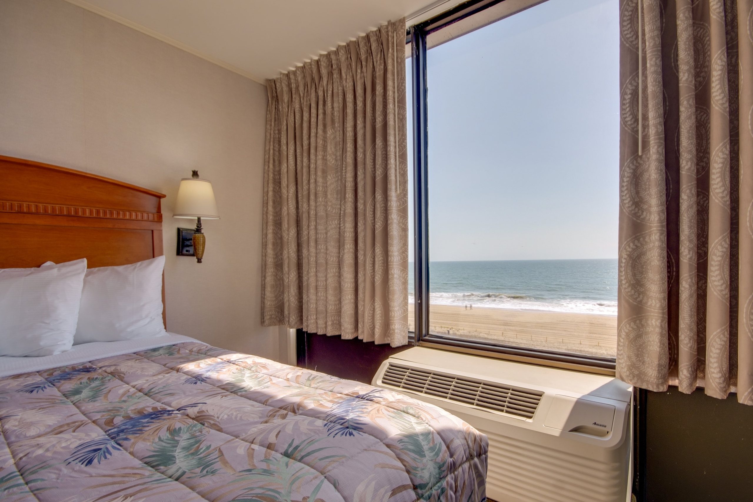 a hotel room with a large bed and a view of the beach