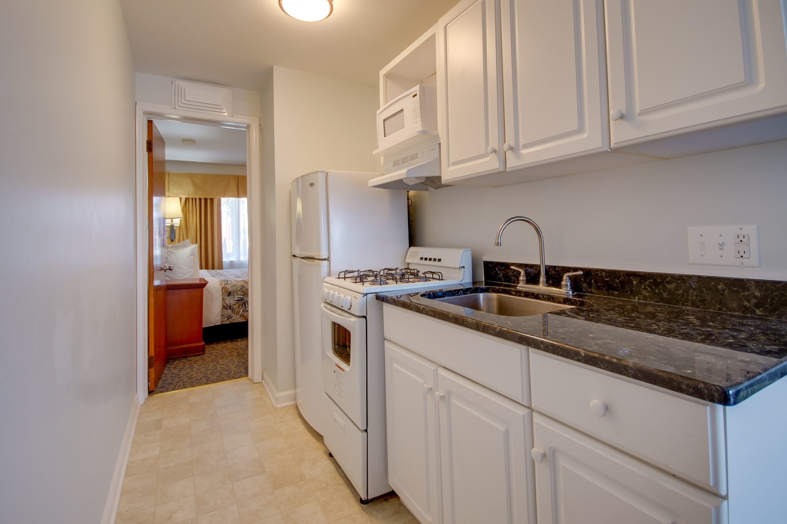 a kitchen with a sink, stove and refrigerator