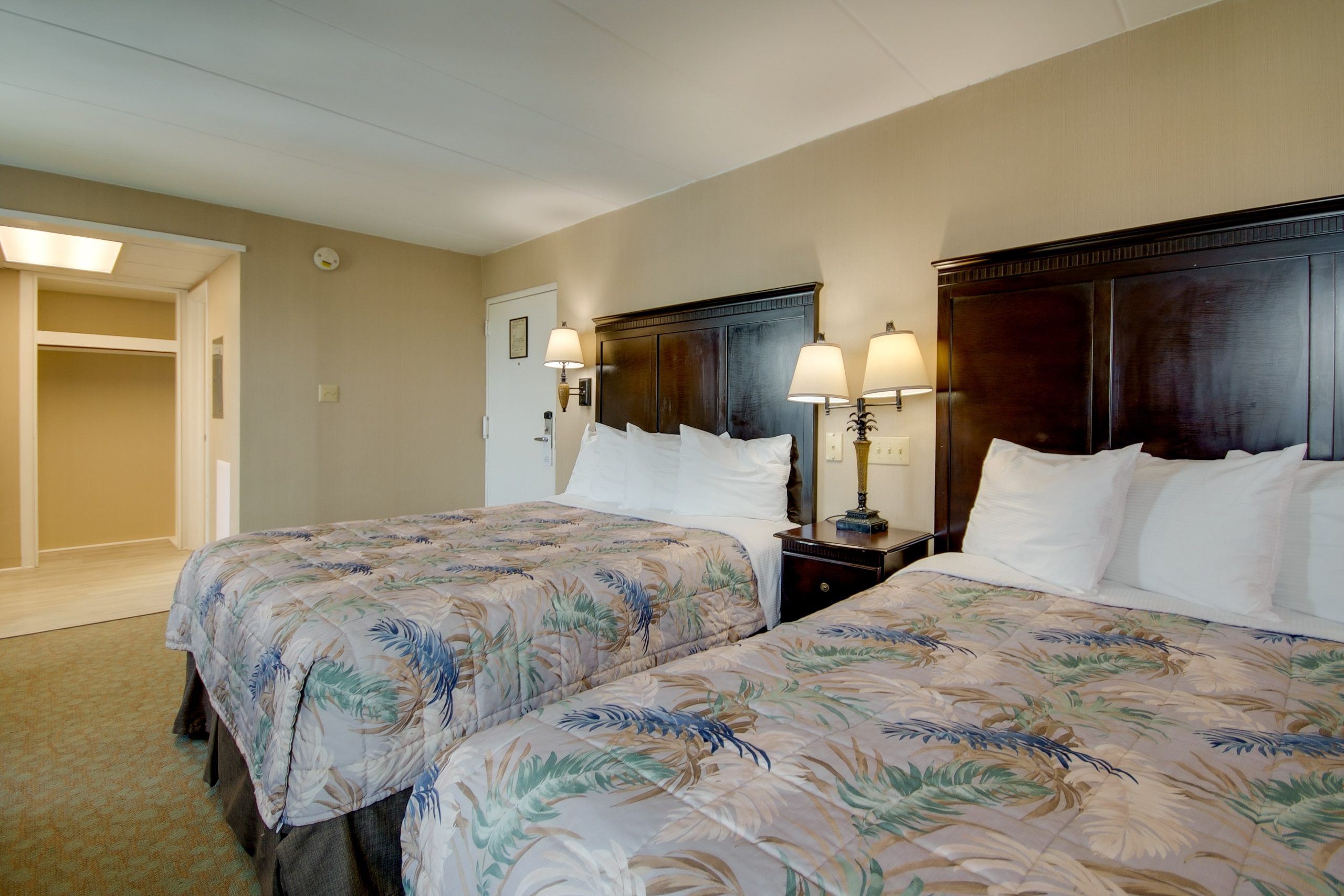 a hotel room with two beds and two lamps