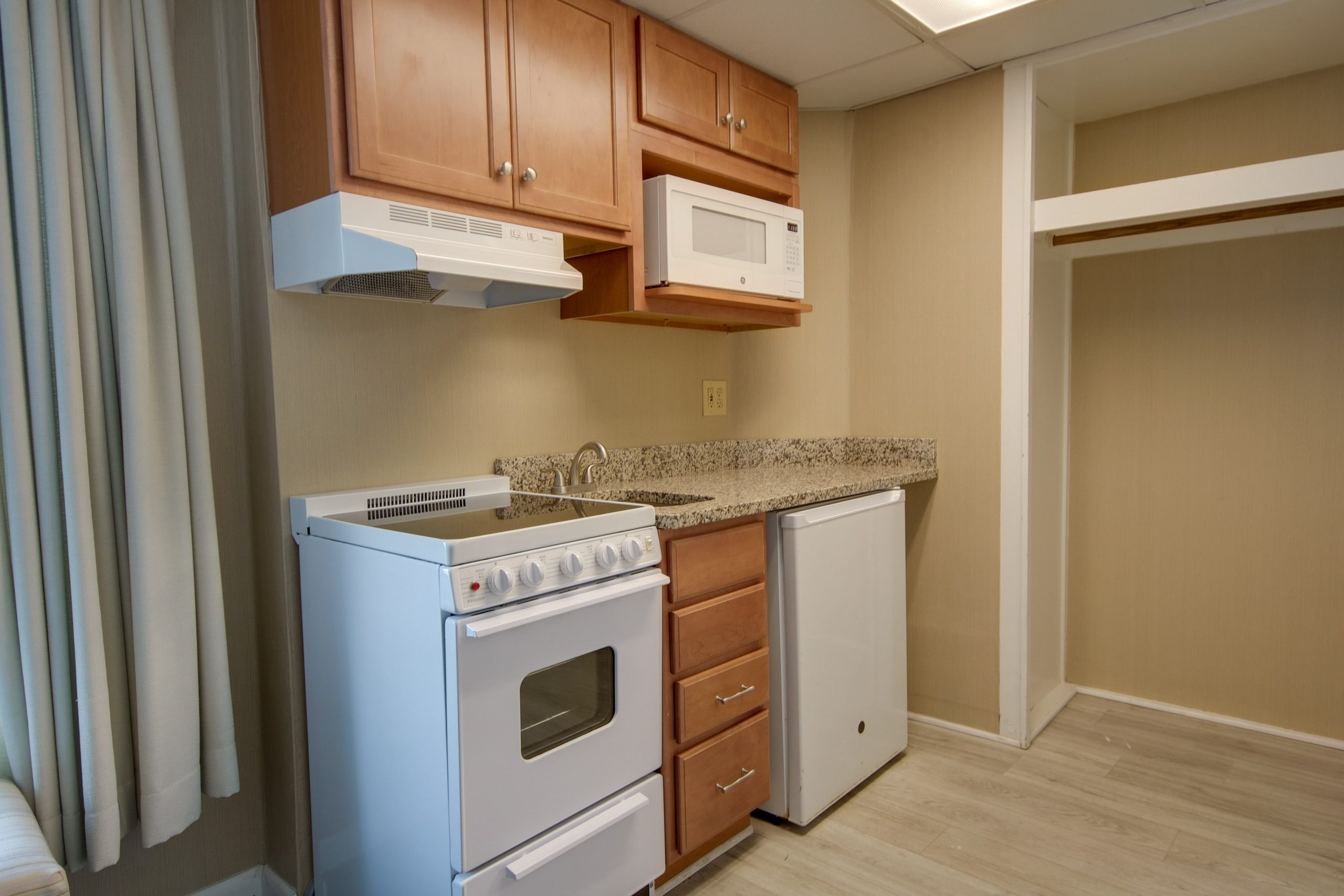 a kitchen with a white stove top oven next to a window