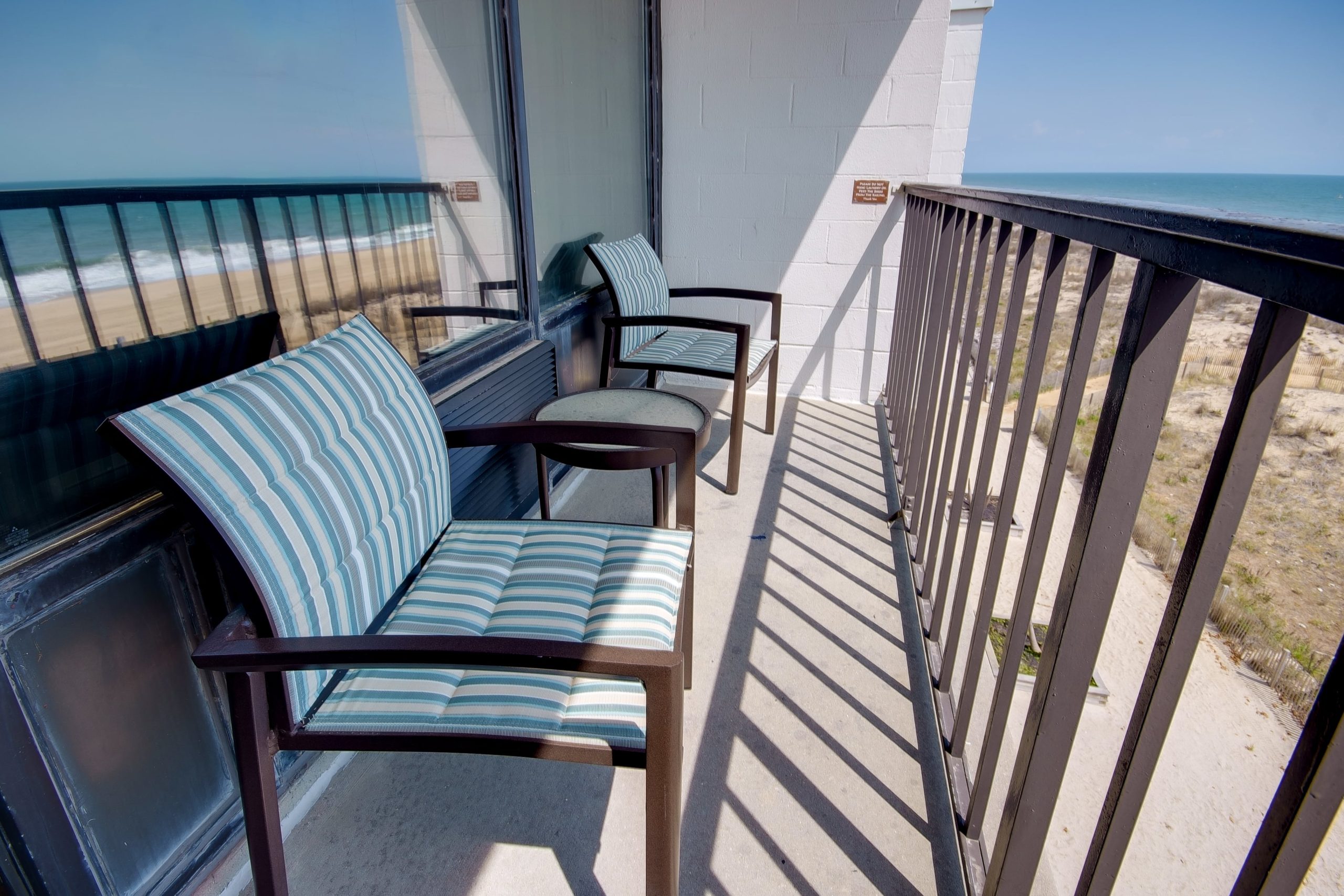 a balcony with chairs and a view of the beach