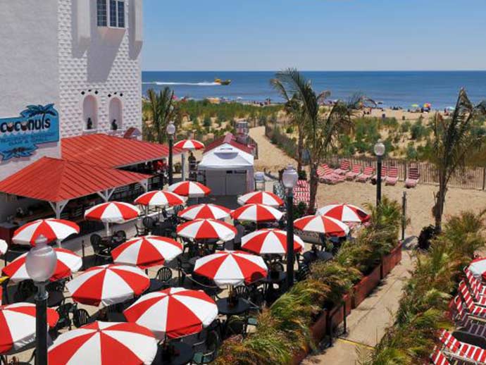 a bunch of red and white umbrellas on a beach