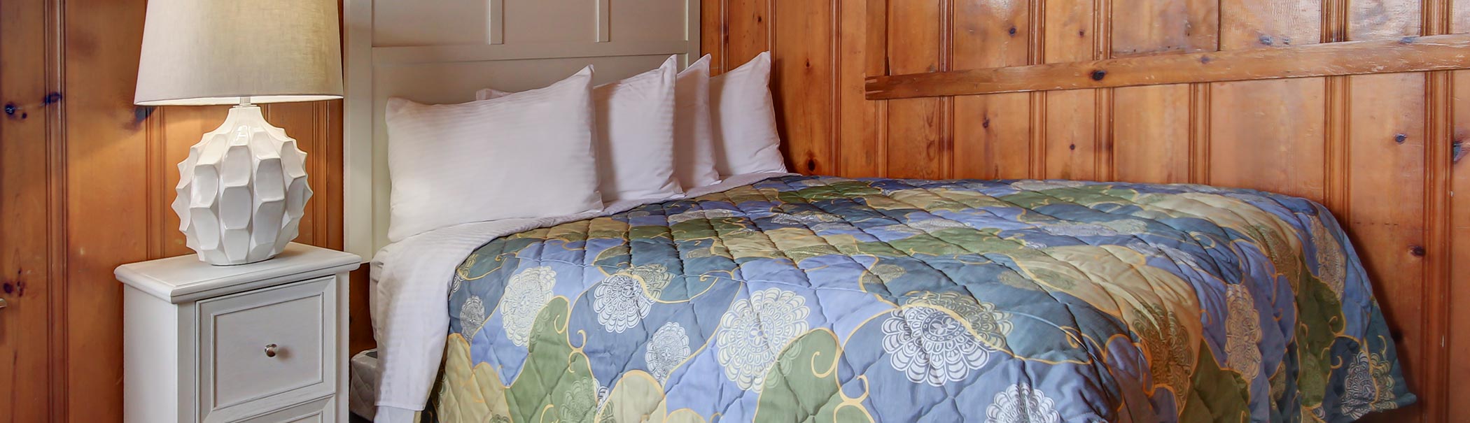 a bedroom with wood paneling and a bed