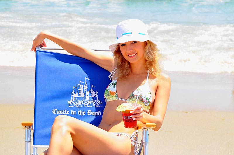 a woman sitting in a chair on the beach