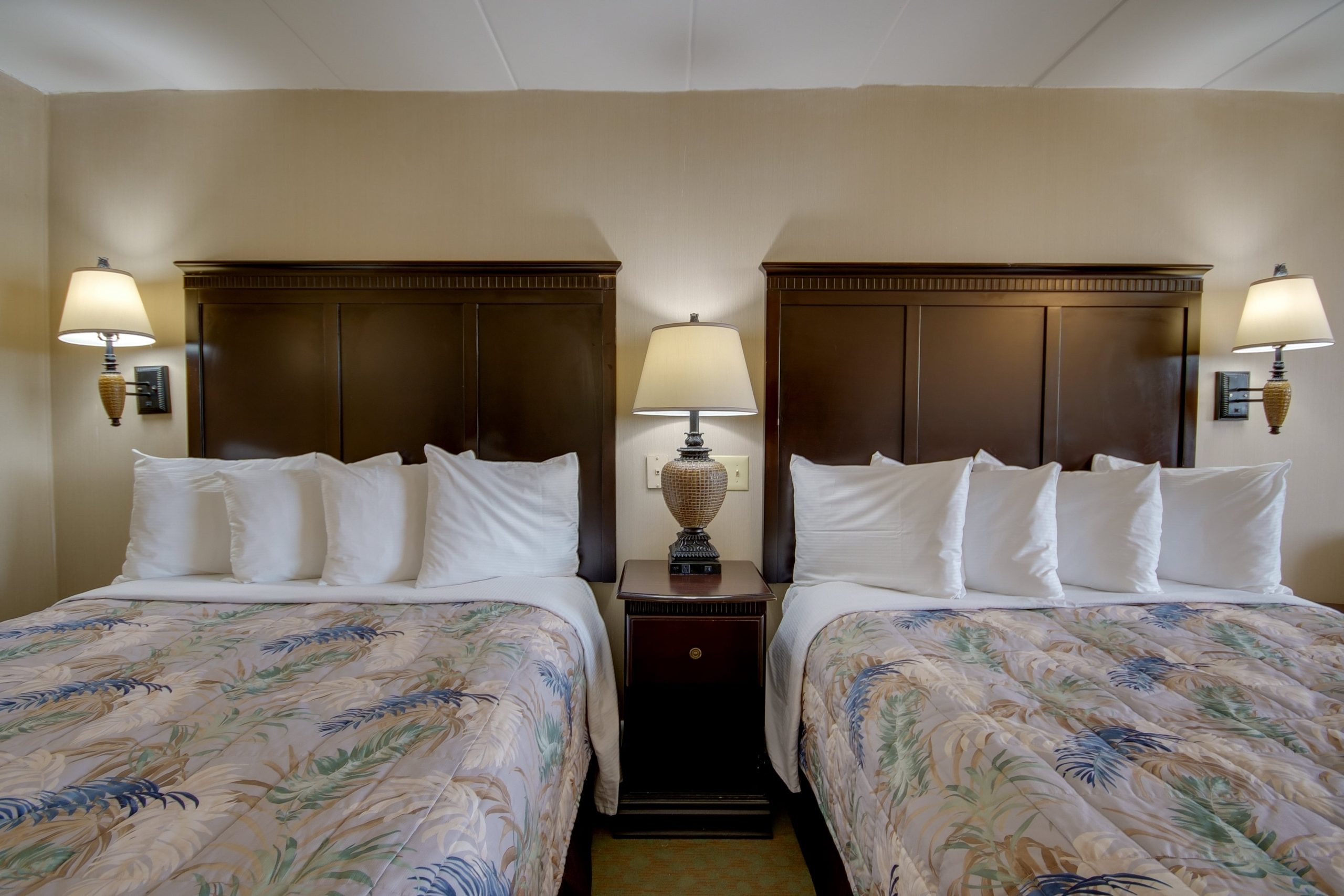 a hotel room with two beds and two lamps