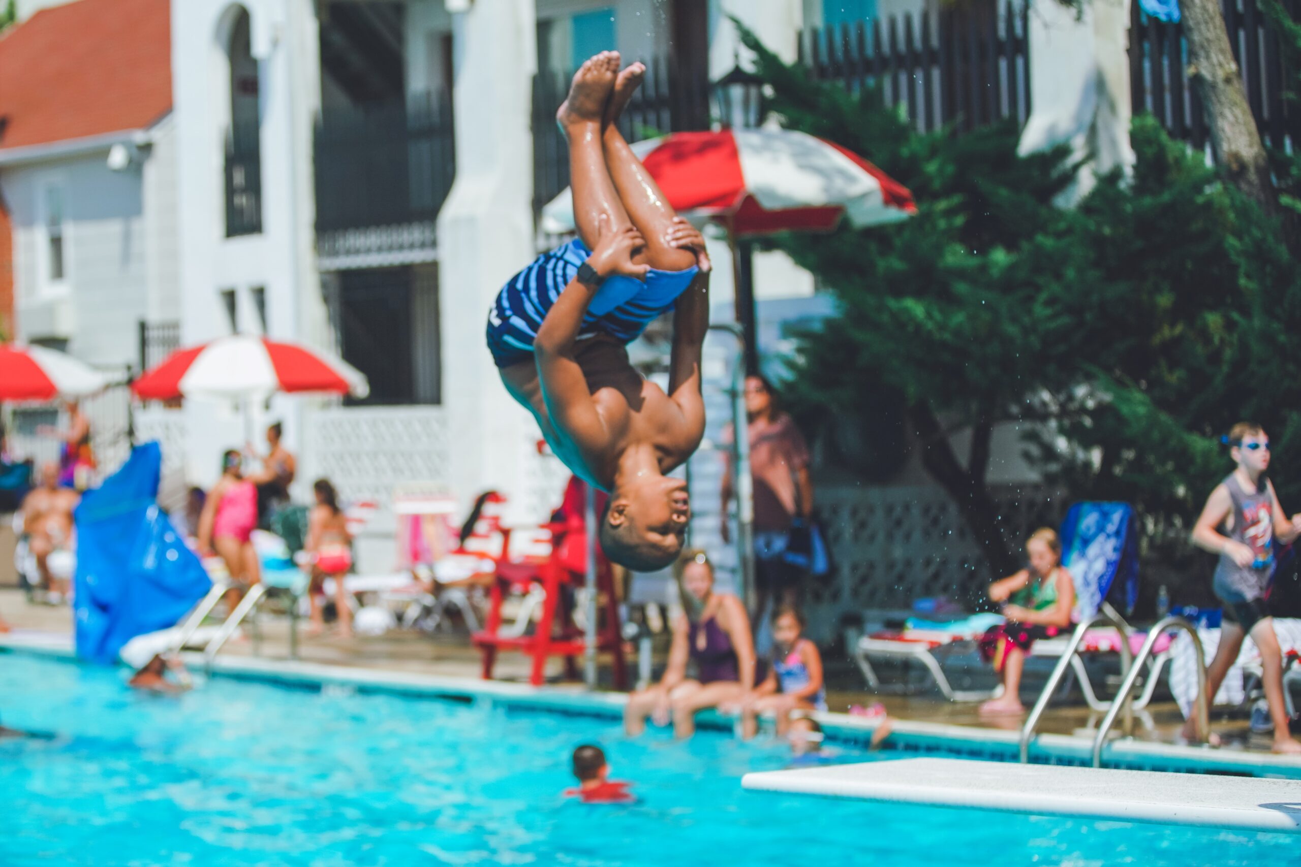 a young boy is doing a handstand in a swimming pool