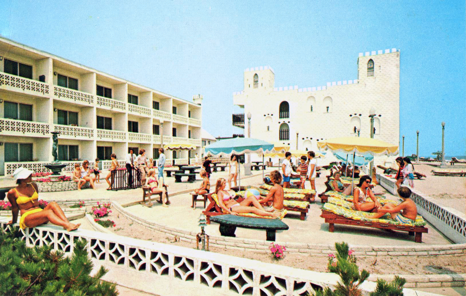 a group of people sitting on top of a sandy beach