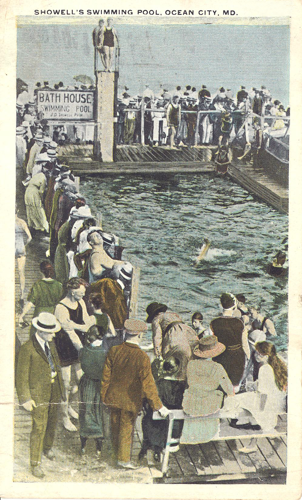 a group of people standing on a pier next to a body of water