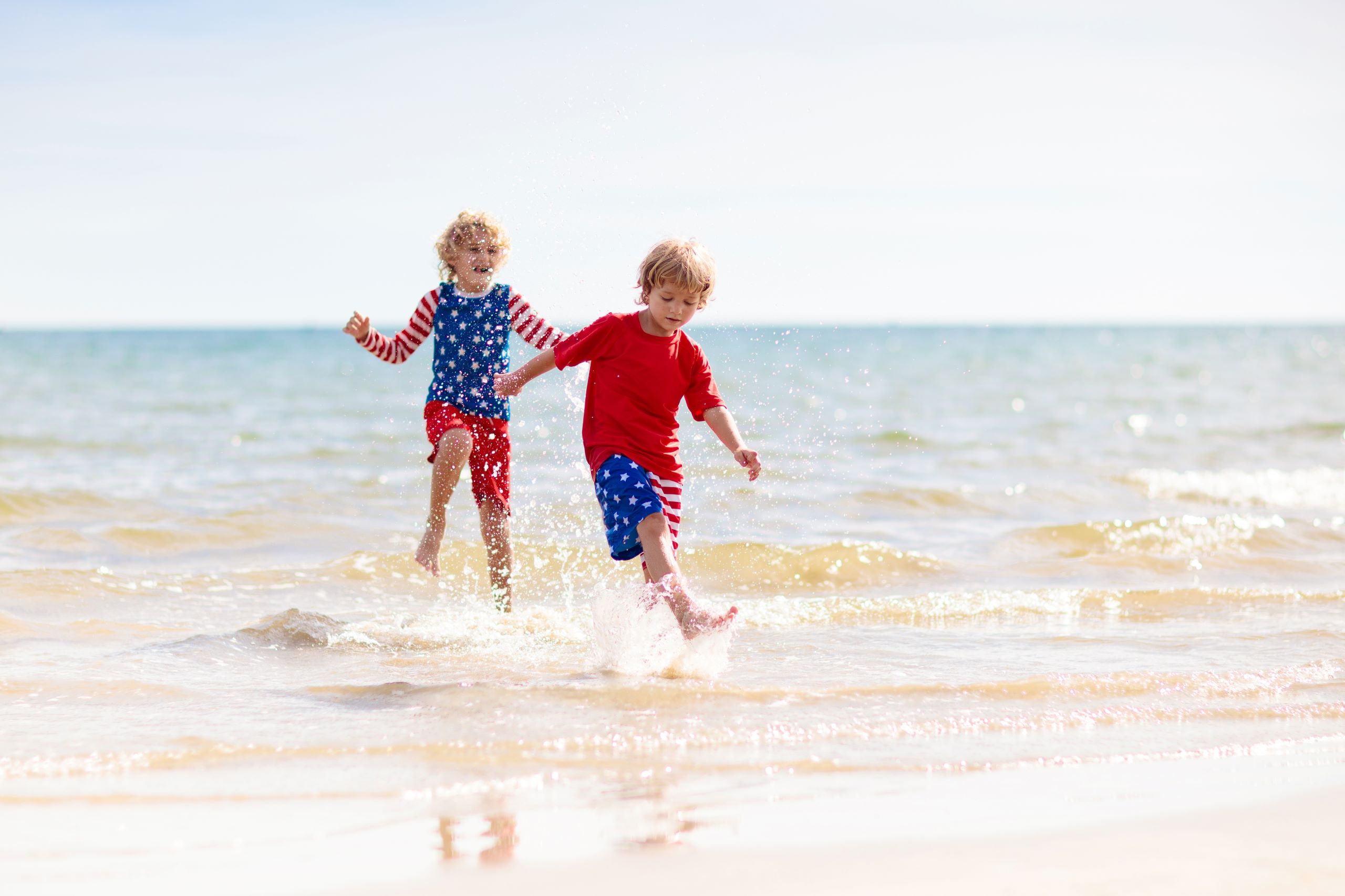 two young boys playing in the water at the beach