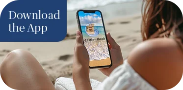 a woman sitting on the beach looking at her phone